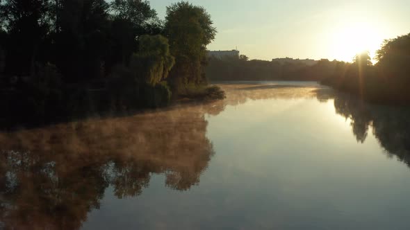 Beautiful morning, summer flight over the river. Fog, trees. alt