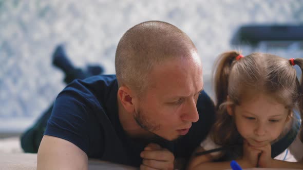 Parent Explains Home Task To Daughter Lying on Floor in Room alt