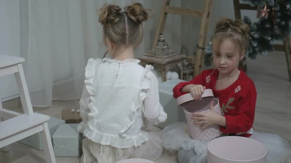 Happy American family celebrating Christmas. Children open a gift at home. alt