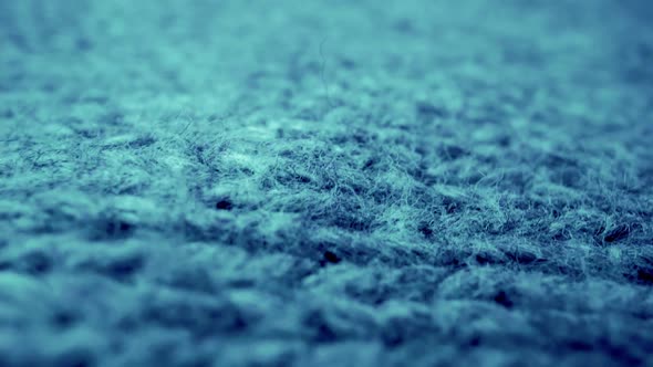 Extreme detail view of sheep wool cloth texture flowing in macro dolly shot. alt