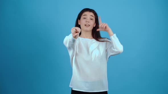 The Disappointed Mischievous Young Woman Points with Her Index Finger Forward and Points with Her alt