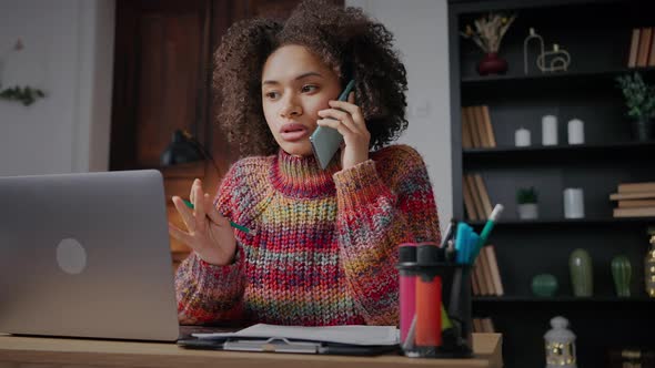 Young Concentrated African American Woman Talking with Client Via Mobile Phone Discussing Order alt