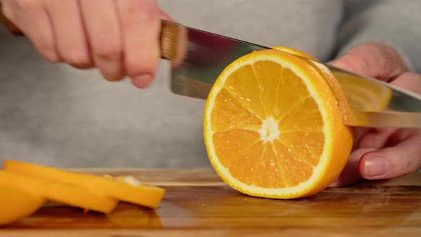 Woman Cutting Oranges Closeup alt