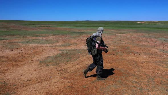 Slow Motion  Tired Soldiersniper Walks Across the Scorching Desert Land