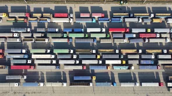 Top view of many trucks with trailers waiting to be unloaded at the port terminal