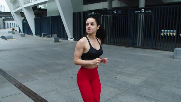 Young Sportswoman Running on Urban Street. Sexy Woman Flirting on Jog Outdoor alt