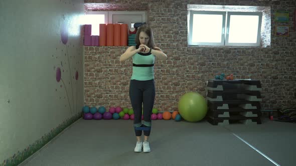 Girl Fitness Instructor Shows a Set of Exercises in the Gym