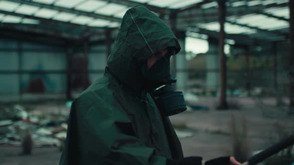 Soldier Man with Gas Mask in a Destroyed Building By War with Torch alt