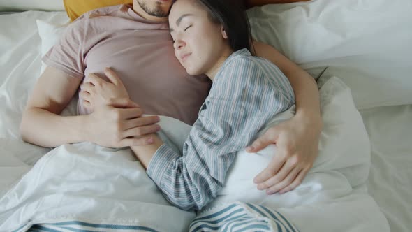 Top View of Girlfriend and Boyfriend Sleeping in Bed Together Embracing Expressing Love alt