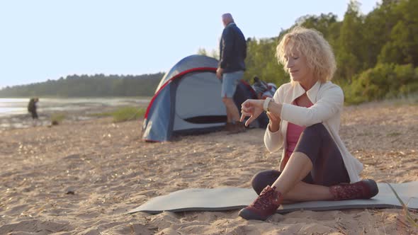 Senior Couple Camping on Sandy Beach Enjoying Holidays Trip alt
