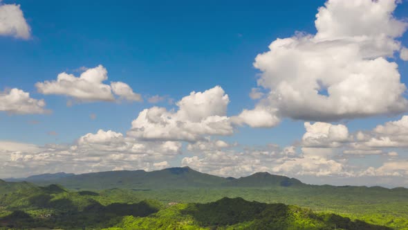 clouds moving over the mountains during the day, clear skies. alt