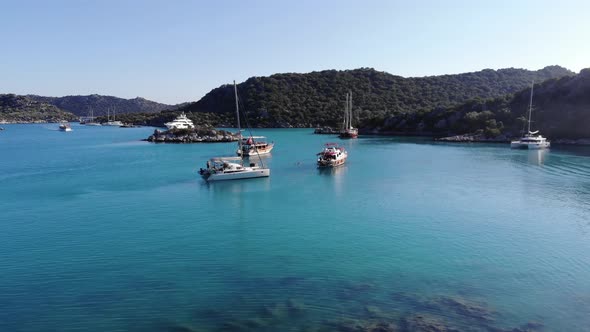 Drone Footage of the Bay with Sailing Yachts in Clear Blue Water and the Mediterranean Coast with alt