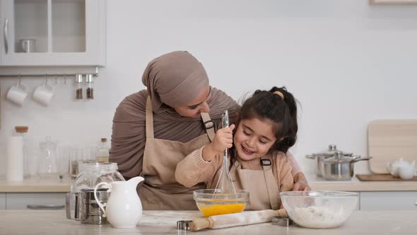Mother In Hijab And Daughter Baking Making Dough In Kitchen alt