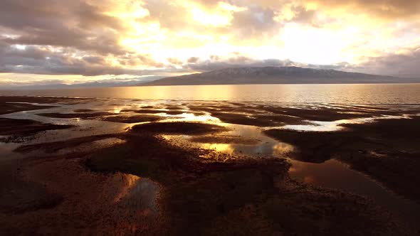 Low flying view reflecting sunset from lake alt