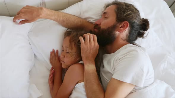 Little Daughter Sleeping with Her Bearded Father While He is Stroking Her Head