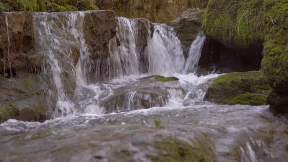 A brook in a gorge in Switzerland in Solothurn with beautiful little waterfalls leads to a place of alt