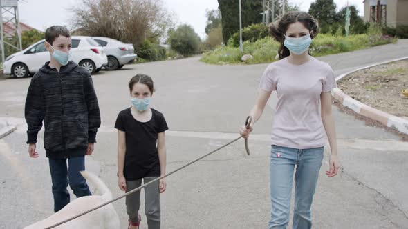 Coronavirus pandemic - kids walking outdoors with face masks to avoid corona alt
