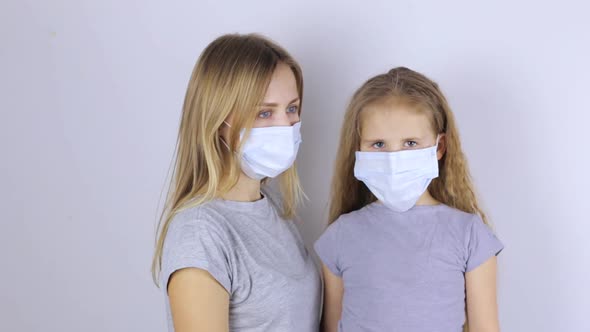 Woman and Girl in Protective Medical Masks.