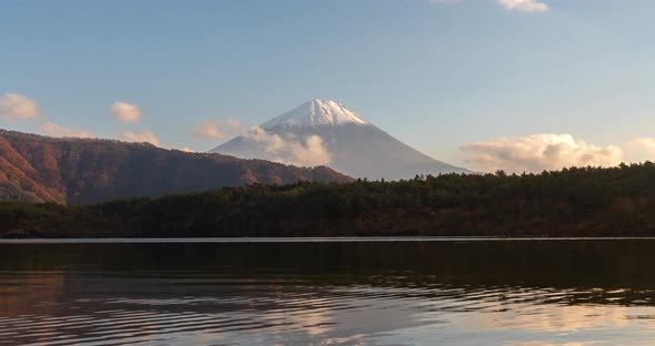 Beautiful time-lapse scenery of lake Saiko with mountain Fuji in blue sky day during autumn