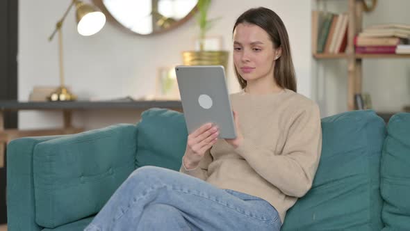 Young Woman Using Tablet on Sofa  alt