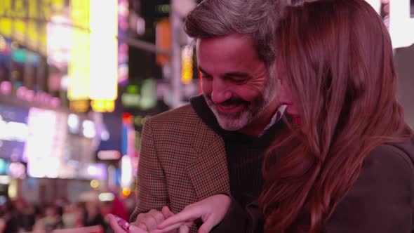 Couple sitting together talking in Times Square, New York City