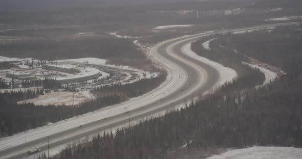 Aerial helicopter shot, tilt down from snowy mountain ridge to show clouds hovering over Alaskan mou