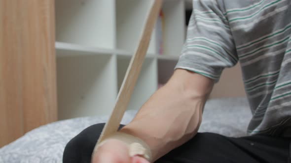 Puts On Bandage On Hand alt