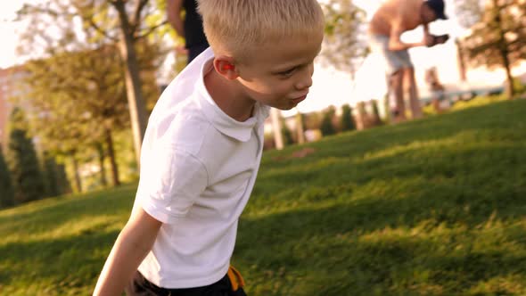 A Little Boy Runs in the Park on the Grass He Spread His Arms to the Side alt