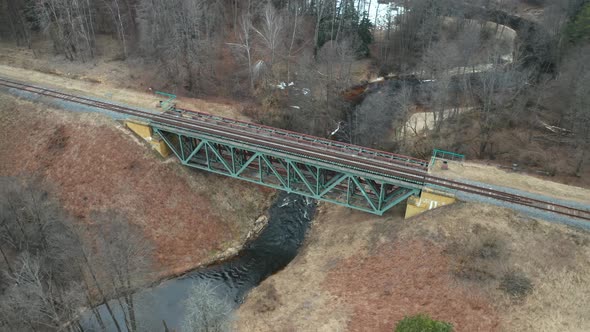 AERIAL: Train Tracks on the Top of Bridge Constructed Above Flowing River