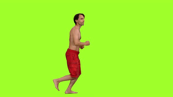 Shirtless Man in Red Shorts Jogging Barefoot