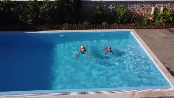 The Mother with Little Daughter Have Fun in the Pool