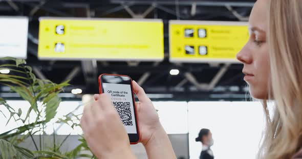Young Woman Travels with QR Code Showing It in Airport on the Screen of Her