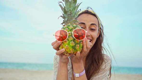 Emotional Portrait Laughing Woman on Beach Holding Pineapple in Red Sunglasses alt