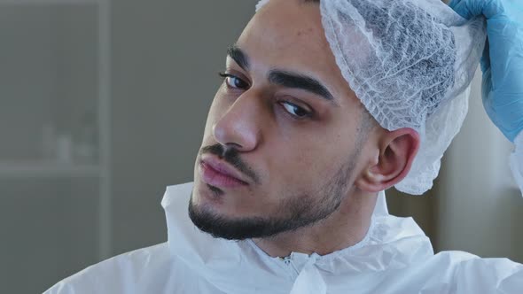 Portrait of Exhausted Tired Young Arab Male Doctor Nurse Practitioner in Protective Uniform Latex alt
