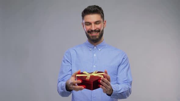 Happy Young Man with Gift Box in Shape of Heart alt