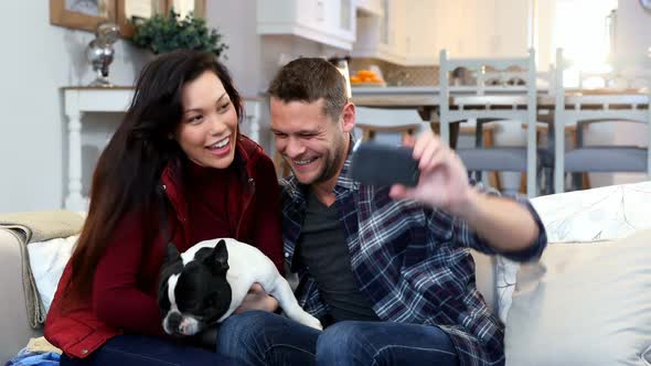 Happy couple taking selfie with pug dog 4k alt