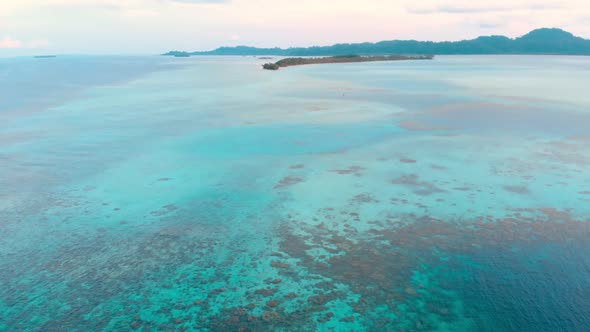 Aerial: flying over coral reef tropical caribbean sea, turquoise blue water. Ind alt