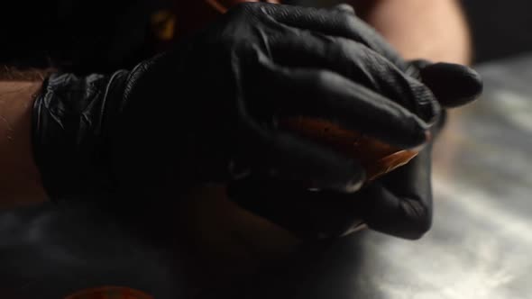 Closeup of Shoemaker Putting Paint on Parts of Light Brown Leather Shoes and Rubbing with Fingers alt