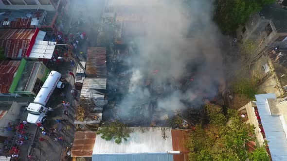 Aerial view Bomberos de Santiago at a house on fire, in city ghetto - static, drone shot alt