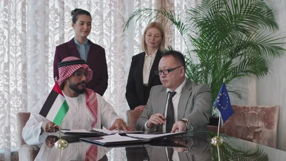 Diplomats From Different Countries Signing Papers During Negotiations alt