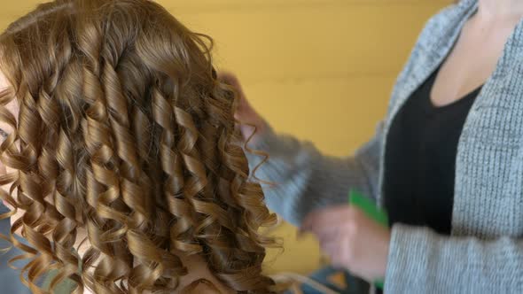 Hairdresser Spraying Hair Product On Redheads Curly Hair, CLOSE UP alt