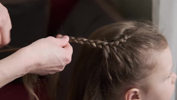 Mother Braids Daughter Pigtails on Hair Head alt