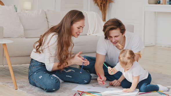 Young Parents Help Little Daughter Toddler Preschool Child Girl Draw Picture with Colored Pencils alt