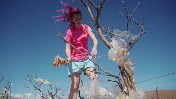 Volunteer Activist Woman in Picking Up Plastic Bags From Dead Tree on Hawaii alt