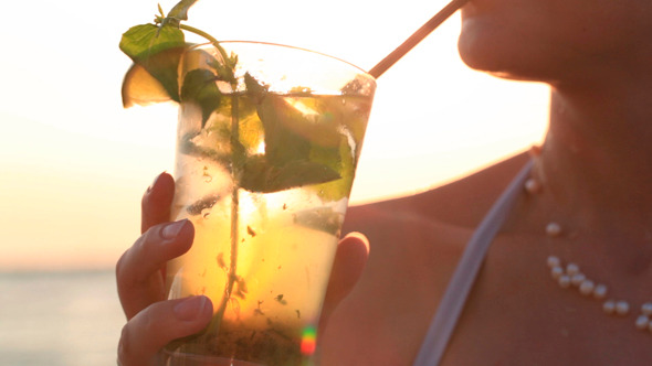 Woman Enjoying a Tropical Mojito Cocktail alt