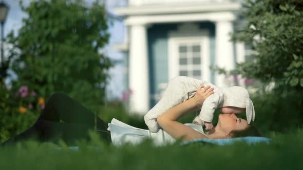 Young Mom Playing with Her Little Daughter Near the House alt