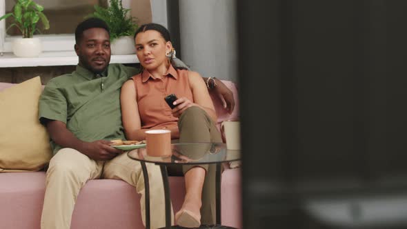 Young Biracial Couple Watching TV At Home alt