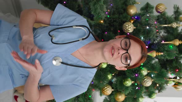 New Year Online Female Doctor Congratulates on Christmas Holidays By Video Link Sitting Background alt