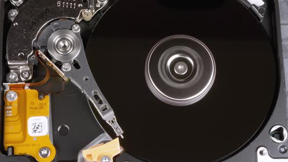 Opened Hard Disk Drive with Spinning Platter. Move of Writing Magnetic Head alt