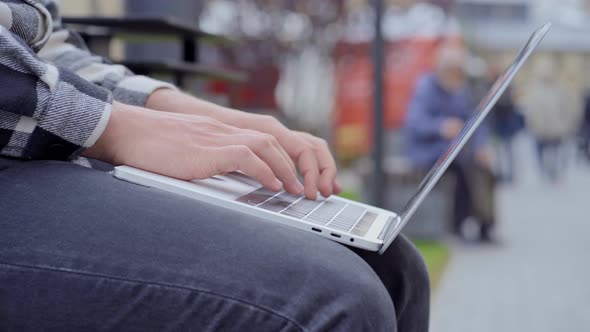 Male hands typing on the laptop.